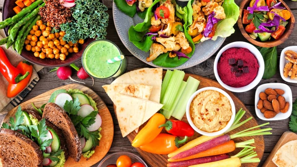 Healthy lunch table with vegetables and salad on a wooden table